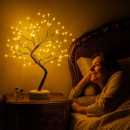 Arbre de vie lumineux Foyanna allumé sur une table de chevet, lumière chaude