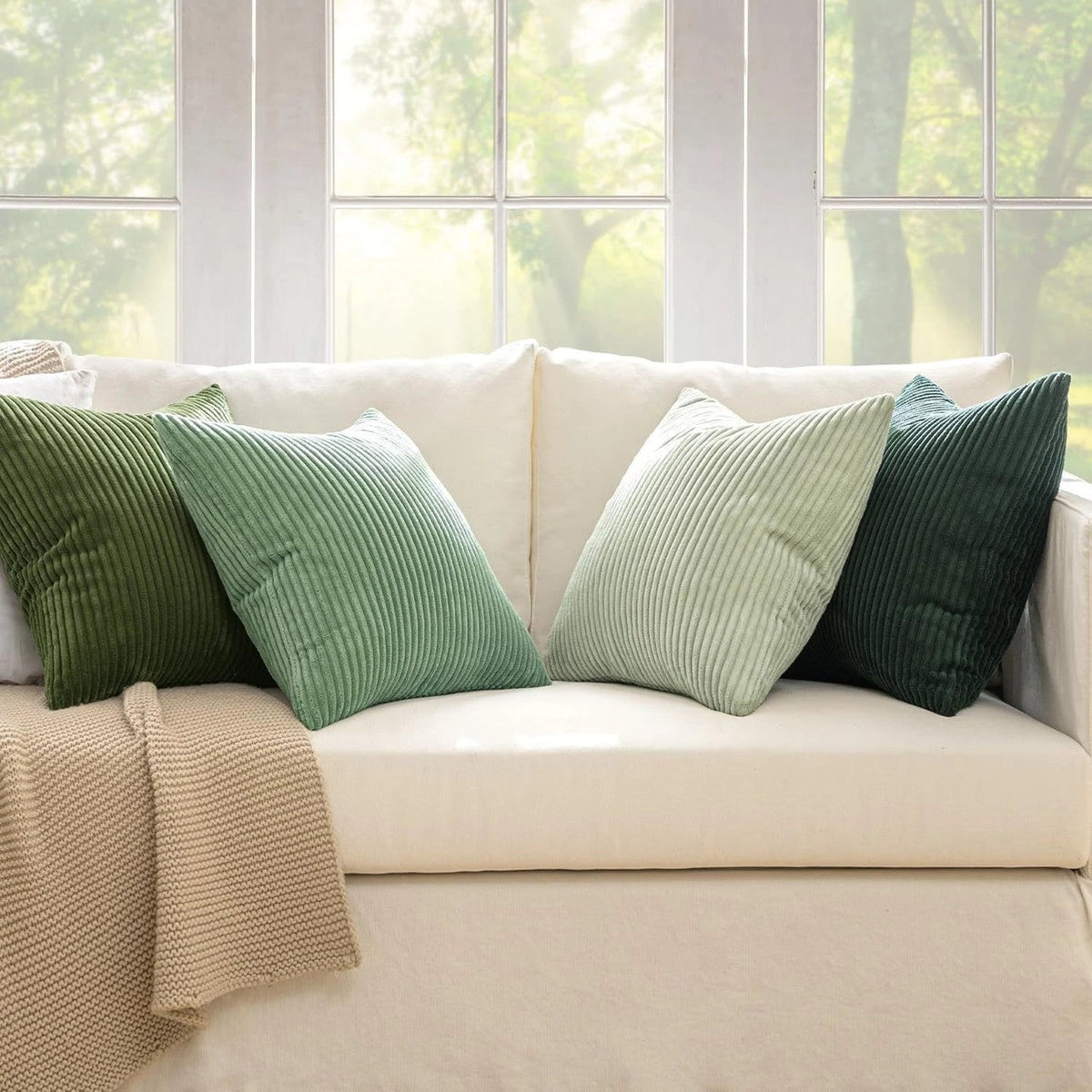 Quatre coussins côtelés sur un sofa crème