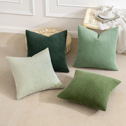 Quatre housses de coussin côtelées posées au sol